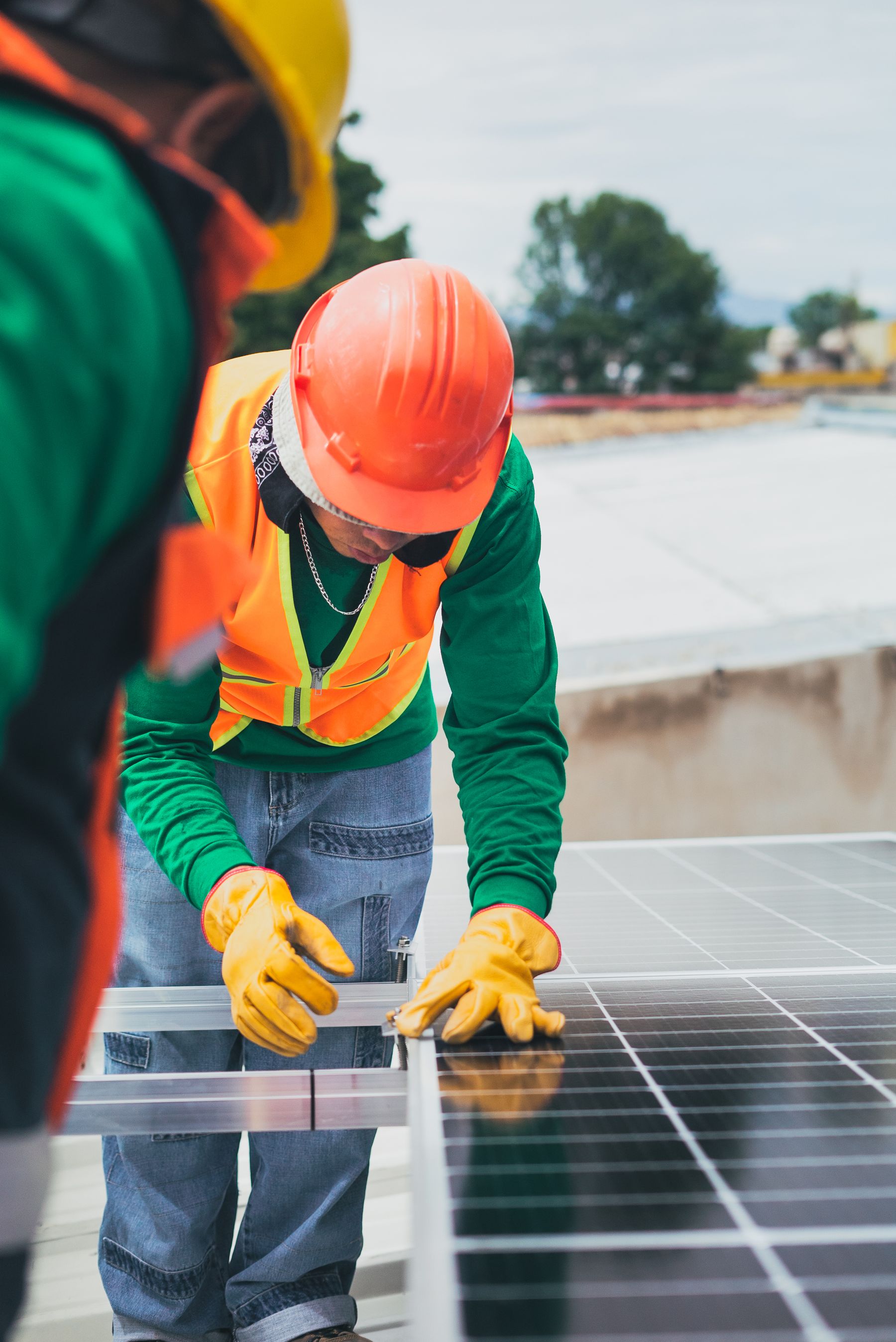 Tecnico in dispositivi di protezione individuale che installa un pannello fotovoltaico in cantiere